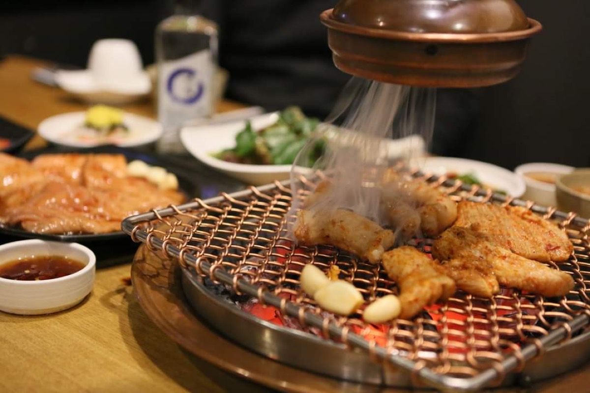 청춘구락부 양념 양대창 숯불구이 — 동판 배기 아래 숯불 석쇠에 굽는 양대창과 마늘